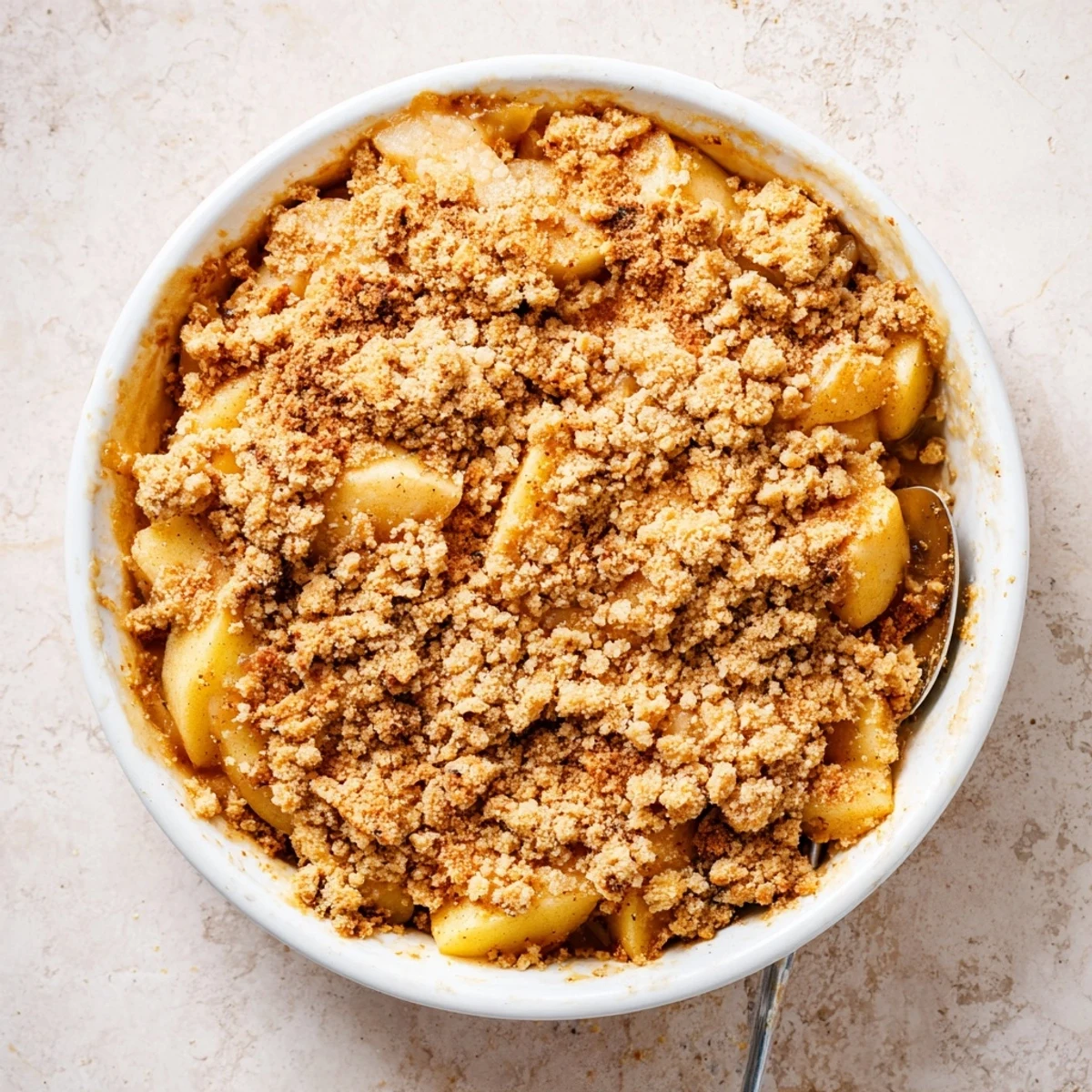 This warm apple and cinnamon crumble displays bubbling, tender apples under a golden, crunchy topping.