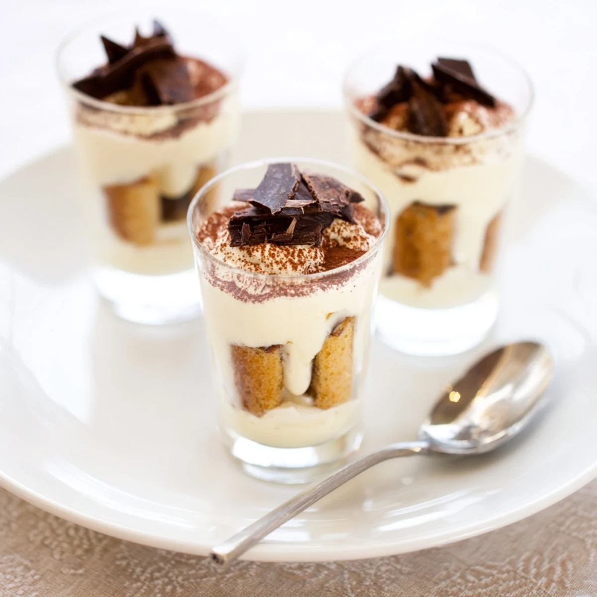 Mini glasses hold beautifully layered Count-down Tiramisu Shots, perfect for an elegant after-dinner treat.