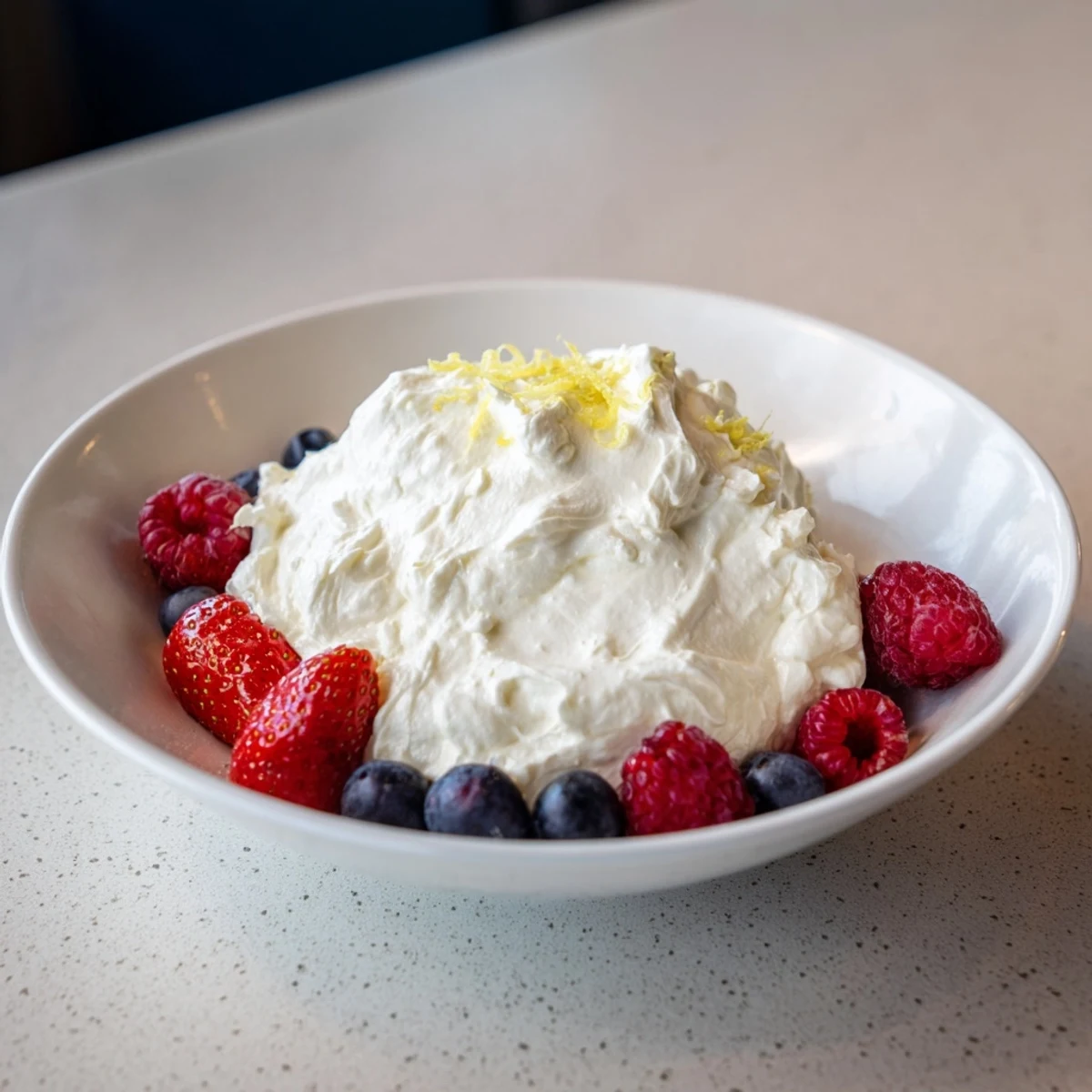 A close-up of a delightful serving bowl filled with Fluffy Cream Cheese Fruit Dip and juicy berry arrangement.