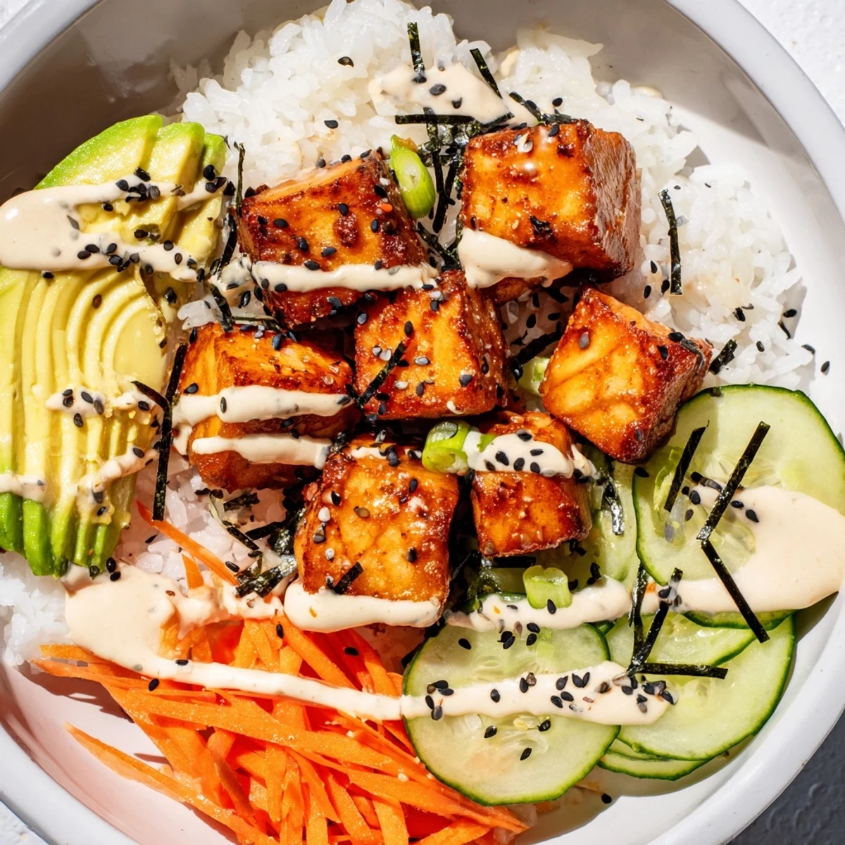 Golden, crispy salmon bites in a bowl, a flavorful mix over fluffy rice and fresh veggies.