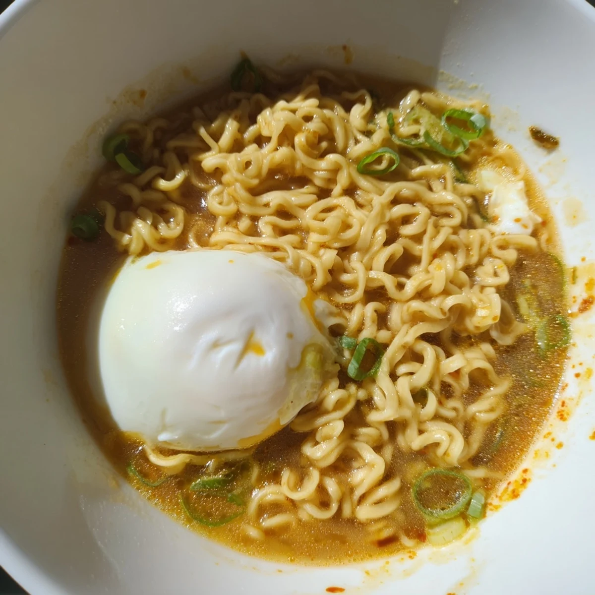 A steaming bowl of upgraded instant ramen, golden yolk, and butter melting, ready to eat.