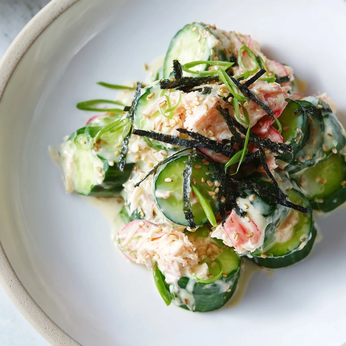 Fresh California Roll Cucumber Salad topped with pickled ginger and sesame seeds, perfect for a light, refreshing meal.