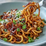 Spicy chili crisp noodles, a quick and savory dish, topped with peanuts.