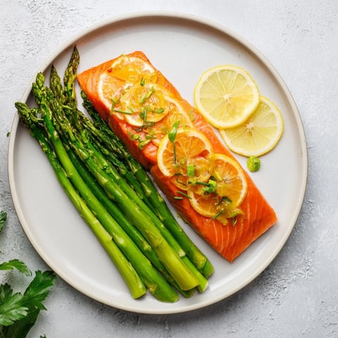 Golden-brown skillet lemon-butter salmon with tender asparagus, a fresh and delicious meal.