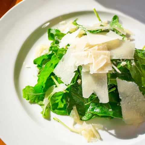 Fresh arugula salad with a bright lemon dressing, Parmesan shavings, and a touch of shallots.