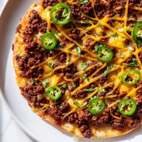 Spicy ground beef pizza base with bubbly cheese, a flavorful, fiery dish to enjoy.
