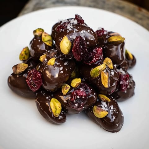 These gorgeous Pistachio and Dried Cranberry Clusters boast a vibrant mix of nuts, fruit, and rich dark chocolate.