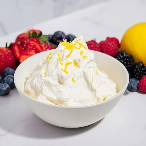 Cool, creamy Fluffy Cream Cheese Fruit Dip with a mountain of colorful berries ready to be enjoyed.
