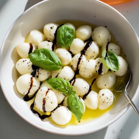 Dazzling close-up of mozzarella pearls, drizzled with olive oil, ready to be enjoyed as a snack.