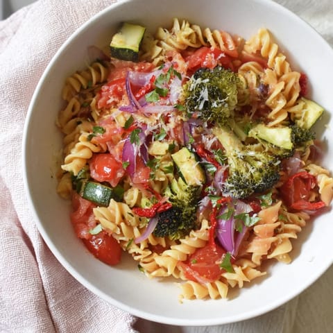 Close-up of air-fried vegetables and ditalini pasta, tossed with fresh herbs, a vegetarian delight.