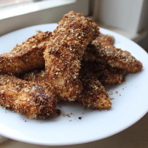 Close-up of perfectly cooked air-fried chicken tenders, with a crunchy breadcrumb coating, ready to eat.