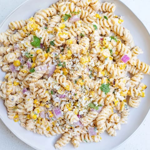 This Creamy Street Corn Pasta Salad showcases a vibrant mix of pasta and fresh, colorful ingredients.