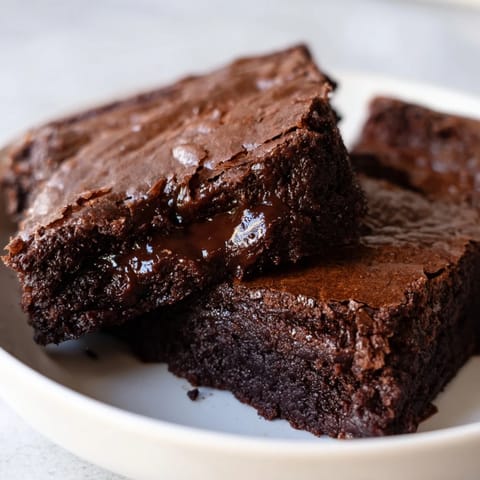 Indulge in Ina Garten's brownie pudding: a molten chocolate dessert topped with crispy baked edges.