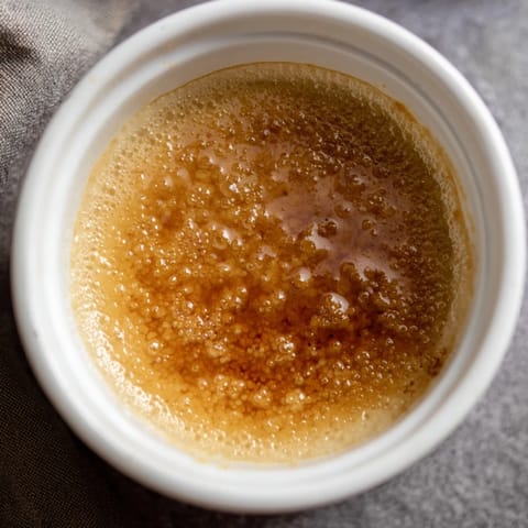 A close-up of a perfectly caramelized 3-Ingredient Crème Brûlée, ready to crack and enjoy.