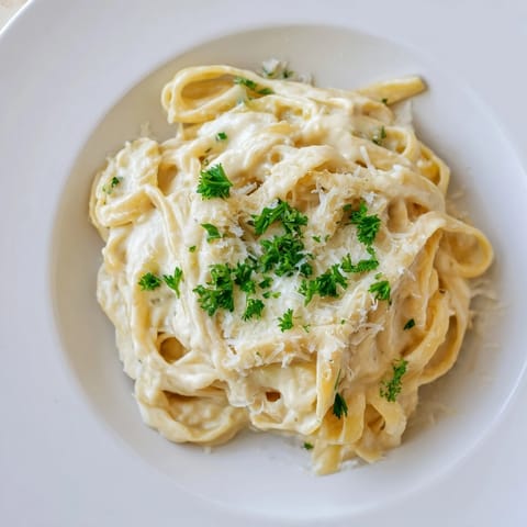 Creamy Roasted Cauliflower Alfredo tossed with golden fettuccine in a rustic skillet for easy family dinner.