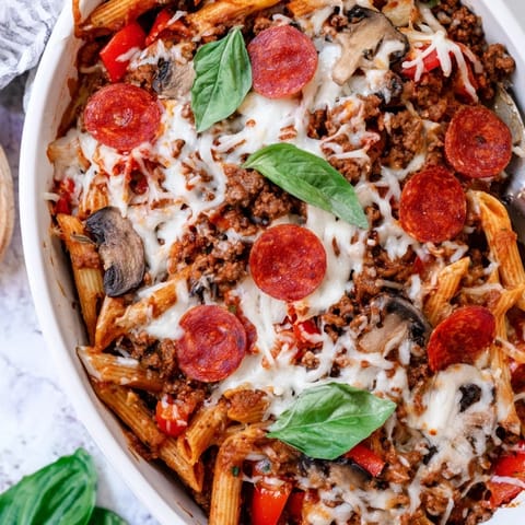 A close-up of the High Protein Italian Beef and Pasta Bake, showing chunky ground beef, diced bell peppers, and spinach in rich red sauce.