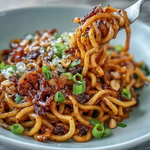 Spicy chili crisp noodles, a quick and savory dish, topped with peanuts.