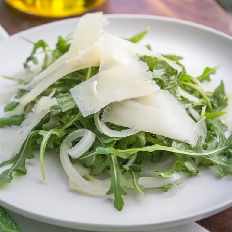 This simple arugula salad features peppery greens coated in tangy lemon dressing, ready to enjoy.