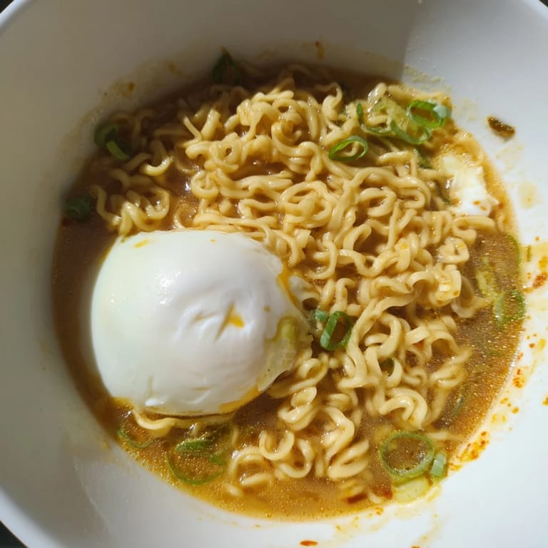 A steaming bowl of upgraded instant ramen, golden yolk, and butter melting, ready to eat.