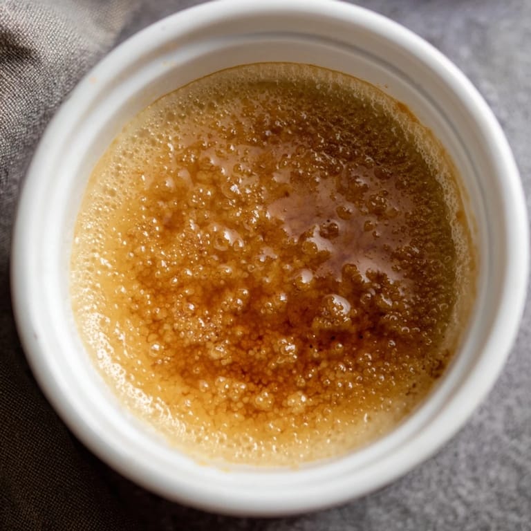 A close-up of a perfectly caramelized 3-Ingredient Crème Brûlée, ready to crack and enjoy.