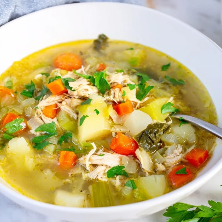 Close-up of Collard Greens, Chicken and Vegetable Soup showing vibrant green collards, carrots, and celery in a savory broth.