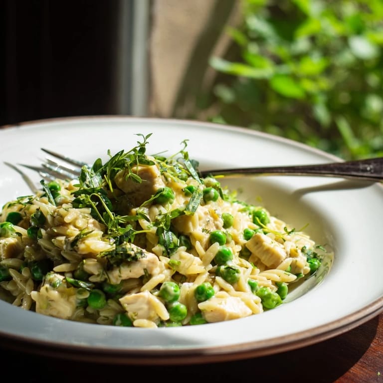 Vibrant green peas and bright lemon zest highlight this easy one-pan Mediterranean-inspired Lemon Herb Chicken Orzo Skillet.