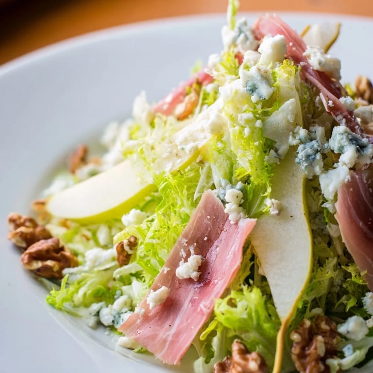 Fresh slices of ripe pear and creamy blue cheese nestled among crisp frisée leaves in this Frisée, Pear, Blue Cheese, and Crispy Prosciutto Salad.