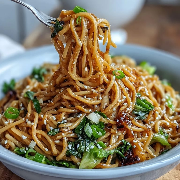 Vibrant noodle dish featuring fresh ginger, scallions, and sautéed greens, perfect for a quick vegetarian meal.