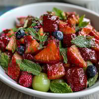 Bright strawberry lemonade fruit salad with juicy strawberries, blueberries, and pineapple, drizzled with a tangy lemon-honey dressing.